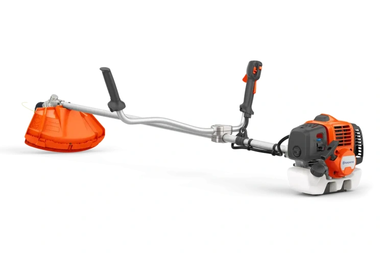 Wykaszarka Husqvarna 333R Mark II stoi bokiem na białym tle. Ma pomarańczową plastikową głowicę, metalowy uchwyt, czarny silnik, prowadnicę i dźwignie sterujące. Widoczne szczegóły konstrukcji.