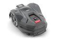 Robot koszący Husqvarna Automower® 310E NERA w kolorze szarym, z widocznym przyciskiem startu oraz czerwonym przyciskiem STOP. Ujęcie z boku, produkt leży na płaskiej powierzchni. Na obudowie znajduje się logo Husqvarna oraz oznaczenia.