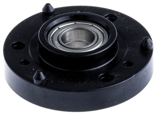 Obudowa łożyska do Automower 310/405X Husqvarna w kolorze czarnym, o okrągłym kształcie. Widoczny metalowy element łożyska oraz sześć otworów mocujących wokół. Produkt leży na płaskiej powierzchni, z bliska, ukazując detal konstrukcji.