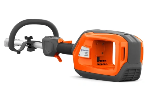 Podkaszarka Husqvarna 525iLK w pomarańczowo-czarnych barwach z uchwytem D. Widok z boku na jednostkę napędową, otwartą komorę z logo, metalowy wałek i przycisk uruchamiający.