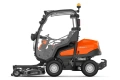 Rider Profesjonalny P525DX Husqvarna w pomarańczowo-szarym kolorze, widok z boku z nożem Combi 155. Kabina z przeszklonymi drzwiami, ergonomiczną kierownicą i wskaźnikami, na jednolitym tle z detalami konstrukcji.