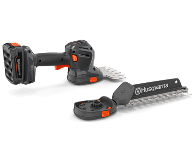 Nożyce do krzewów Husqvarna Aspire™ S20-P4A, szaro-czarne, z akumulatorem i ładowarką. Widok z boku, uchwyt, ostrze, regulacja cięcia i logo. Nowe narzędzie.
