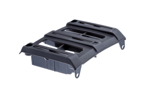 Pokrywa ochronna wykaszarki Husqvarna 545RX/545FR w kolorze czarnym, wykonana z tworzywa sztucznego. Z przodu posiada otwory wentylacyjne, a z boku widoczne zaczepy mocujące. Ujęcie z boku, produkt leży na jednolitym tle.