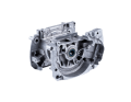 Skrzynia korbowa wykaszarki Husqvarna 545RX/545FX/545FR w kolorze srebrnym, metalowa, z widocznymi elementami mocującymi. Ujęcie z boku, ukazujące detal otworu, w którym umieszczony jest łożysko. Produkt leży na jednolitym, zielonym tle.