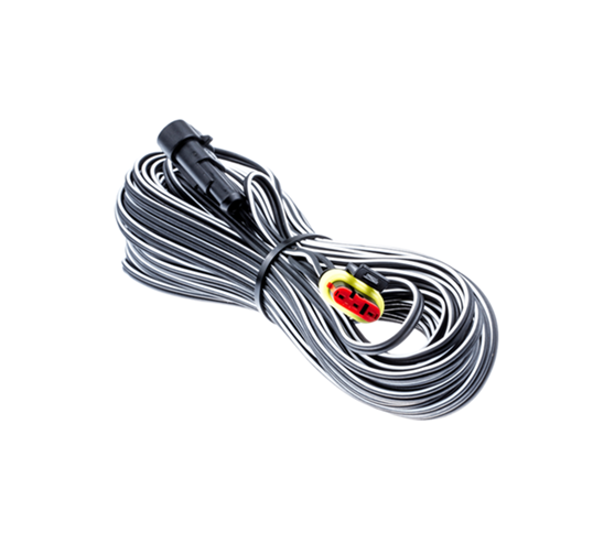 Przewód niskonapięciowy 20m do stacji ładującej, złożony, z czarno-białym splotem. Na jednym końcu widoczna złącze z czerwoną i żółtą wtyczką. Ułożony na jasnym tle, co podkreśla jego szczegóły.