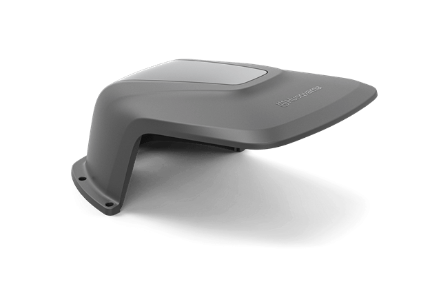 Osłona dla Automower Aspire R4 Husqvarna w kolorze szarym, wykonana z trwałego materiału, pokazana z boku. Produkt ma gładką powierzchnię oraz widoczne logo Husqvarna. Kształt aerodynamiczny, przeznaczony do osłaniania urządzenia.