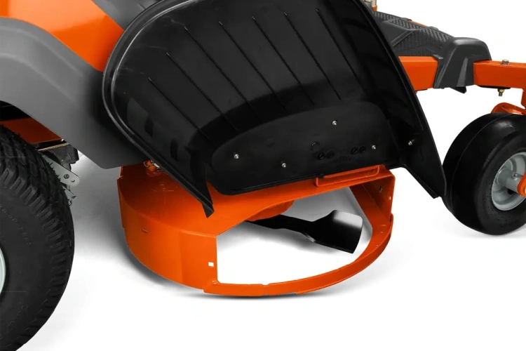 Pomarańczowa kosiarka Husqvarna Z242F z zerowym promieniem skrętu, widoczna z boku. Metalowe ostrze pod zaokrągloną obudową, czarna teksturowana pokrywa, koła z szerokim bieżnikiem.