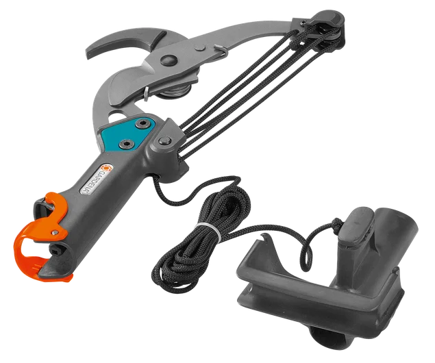 Nożyce dwuostrzowe Gardena w kolorze szarym z pomarańczowymi akcentami, z podwójnymi głowicami tnącymi i mechanizmem linkowym. Produkt leży na jednolitym tle. Widoczny uchwyt z według materiału i dodatkowe akcesorium do mocowania.