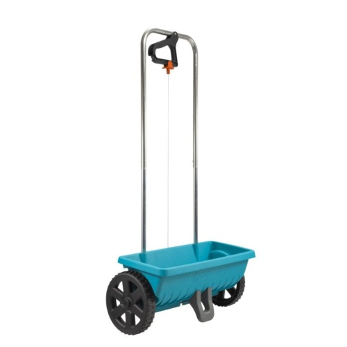 Siewnik uniwersalny L Gardena w kolorze błękitnym, wykonany z tworzywa sztucznego, na dużych czarnych kołach. Produkt stoi na powierzchni, z ergonomiczną rączką do ręcznego prowadzenia. Widoczny system dozowania nasion na spodzie urządzenia.