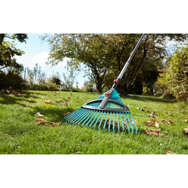 Regulowane grabie wachlarzowe Gardena 35-52 cm z ergonomicznym metalowym trzonkiem, niebiesko-szare, idealne do sprzątania ogrodu, na trawie z liśćmi, widok z boku.