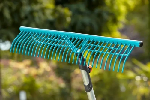Grabie do trawy Gardena o szerokości 60 cm, w kolorze błękitnym. Prosta konstrukcja z długimi zębami, idealna do zbierania trawy i liści. Uchwycona z boku w ogrodzie, z metalowym trzonkiem i ergonomicznej rączce.