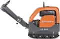 Zagęszczarka Husqvarna LG 504 o pomarańczowej obudowie i szarej podstawie, widoczna z boku. Posiada uchwyt do prowadzenia oraz napisy Husqvarna i LG 504. Maszyna jest na prostym tle, co ułatwia skupienie na jej kształcie i detalach.