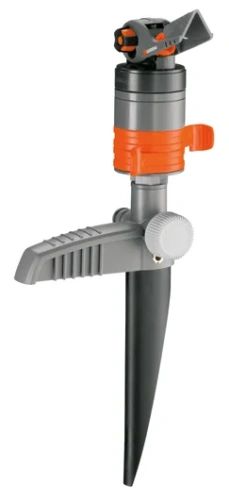 Zraszacz turbinowy na szpilce w kolorze szarym z pomarańczowymi akcentami, posiada regulowany dysz, stabilną podstawę oraz ergonomiczną rączkę. Ujęcie frontalne. Idealny do ogrodu, umieszczony na trawniku, bez dodatkowych elementów w tle.