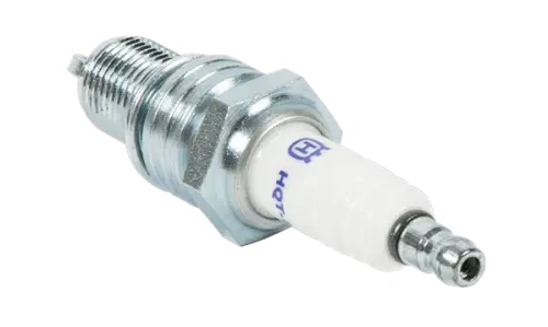 Świeca zapłonowa HQT-11 Resistor, w metalowej obudowie z niklowanym wykończeniem, z ceramicznym wkładem w białym kolorze. Produkt ukazany w zbliżeniu, leżący pod kątem, z widocznym logo na korpusie.