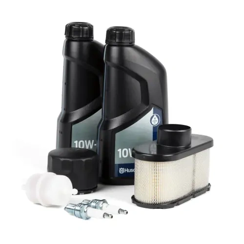 Zestaw serwisowy Husqvarna R420TS AWD zawiera dwa czarne butelki oleju 10W, filtr powietrza oraz zestaw świec zapłonowych. Elementy ułożone na białym tle, w prostym układzie, zapewniające wyraźny widok wszystkich komponentów.