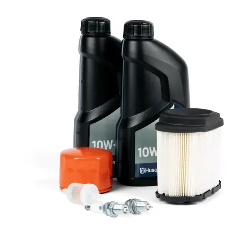 Zestaw serwisowy Husqvarna R419TS AWD z dwoma czarnymi butelkami oleju 10W-, filtrem powietrza w białym cylindrze, czerwoną pokrywą oraz dwoma świecami zapłonowymi. Elementy są ułożone na białym tle, co umożliwia łatwe ich odróżnienie.