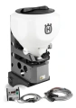Rozsiewacz obrotowy P520DX/P525DX Husqvarna w kolorze białym z metalową podstawą. Stojący, z widocznym logo Husqvarna. W zestawie kontroler i przewody. Produkt na jednolitym tle, ukazujący detale konstrukcyjne i akcesoria.