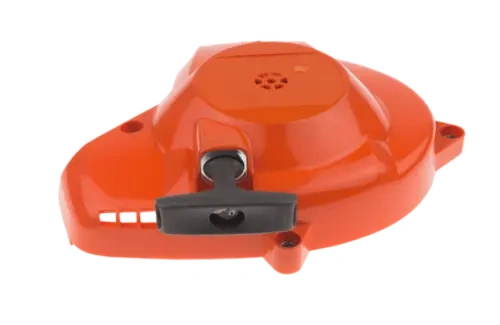 Rozrusznik nożyc Husqvarna 122HD60/122HD45 w kolorze pomarańczowym z czarnym uchwytem. Zbliżenie na górną część produktu, ukazujące teksturę i detal mocowania. Widoczna perforacja wentylacyjna. Produkt leży na białym tle.