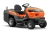 Traktor Husqvarna TC 215T w pomarańczowym kolorze, z ergonomicznym siedzeniem, dużymi kołami, widok z boku na deskę rozdzielczą i logo, solidna konstrukcja z systemem koszenia, idealny do ogrodu.