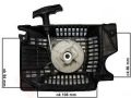 Starter twardy, rozruch T2 piły, widok z góry. Widoczne wymiary: 108 mm x 94 mm x 86 mm. Na zdjęciu czarna obudowa z siatkowymi detalami, centralny mechanizm uruchamiający w kolorze jasnoszarym, uchwyt do szarpania w tylnej części.
