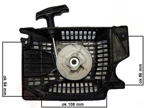 Starter twardy, rozruch T2 piły, widok z góry. Widoczne wymiary: 108 mm x 94 mm x 86 mm. Na zdjęciu czarna obudowa z siatkowymi detalami, centralny mechanizm uruchamiający w kolorze jasnoszarym, uchwyt do szarpania w tylnej części.