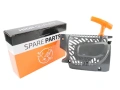 Twardy, wzmocniony rozrusznik szarpaka T17 piły, w kolorze szarym z pomarańczowym uchwytem. Ujęcie z boku, ukazujące szczegóły faktury oraz otwory wentylacyjne. Obok widoczny karton z logo SPARE PARTS na białym tle z pomarańczowymi akcentami.