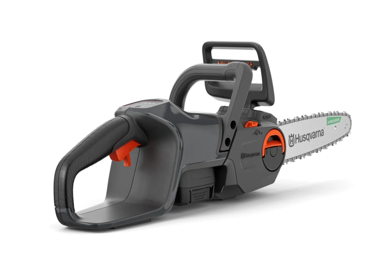 Pilarka Husqvarna Aspire™ C15X-P4A z akumulatorem, w kolorze szarym z pomarańczowymi akcentami. Ujęcie z boku, pokazujące uchwyt i górną część narzędzia, z widocznym logo na obudowie oraz prowadnicą. Produkt leży na prostym, ciemnym tle.