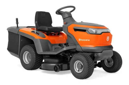 Traktor TC110i Husqvarna w kolorze pomarańczowym. Ujęcie z boku, z widocznym siedzeniem oraz kierownicą. Po lewej stronie dźwignie sterujące. Główne kółka o teksturowanej powierzchni. Obudowa w kolorze pomarańczowym z białym logo Husqvarna.