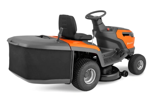 Traktor TC110i Husqvarna w kolorze pomarańczowym i szarym, widok z boku. Posiada czarną, materiałową osłonę tylną oraz metalowe koła. Widoczna kierownica i prosta deska rozdzielcza. Idealny do małych ogrodów, z wbudowanym mechanizmem koszącym.