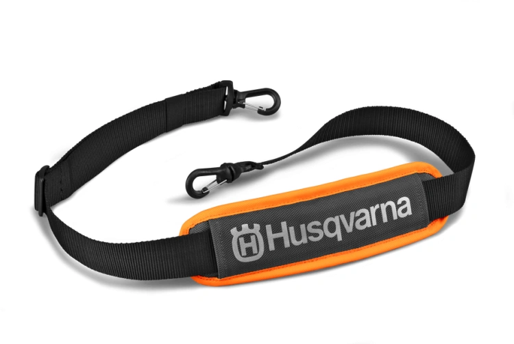 Czarno-pomarańczowa skrzynka na akumulatory Husqvarna z logo na błyszczącej powierzchni. Ułożona poziomo na ciemnym tle podkreślającym kształt produktu.
