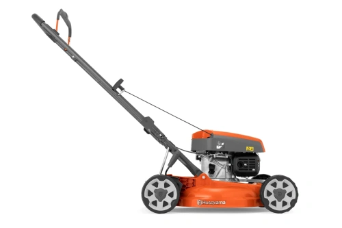 Kosiarka spalinowa Husqvarna LB 144 w pomarańczowo-szarej kolorystyce, z silnikiem umieszczonym z boku. Ujęcie boczne, stojąca, z widoczną rączką i kołami. Logo Husqvarna na podstawie, wyraźne napisy informacyjne na obudowie.