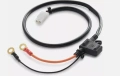 Instalacja elektryczna ridera RC318T Husqvarna z czarnym przewodem, złotymi końcówkami montażowymi i białą wtyczką na białym tle, widok z góry pokazujący szczegóły podłączeń.