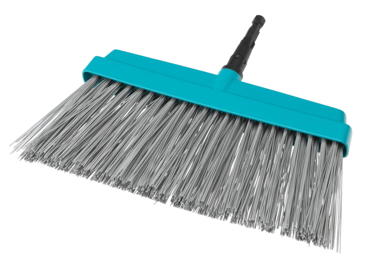 Szczotka do zamiatania tarasów Gardena w kolorze niebieskim, z szeroką głowicą i metalowymi włosiami, ukazana z boku. Uchwyt jest lekko zakrzywiony, wykonany z plastiku. Produkt leży na białym tle, podkreślając jego kształt i detale.