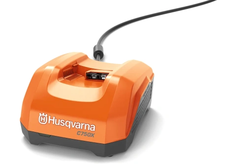 Pomarańczowa ładowarka Husqvarna 40-C750X z przodu, prostokątna obudowa, górne złącze akumulatora, logo i oznaczenie modelu na obudowie, kabel zasilający z tyłu.