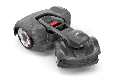 Automower® 435X AWD NERA robot koszący w kolorze szarym, z widocznymi białymi kołami i pomarańczowymi elementami. Ujęcie z boku, ukazujące górną część oraz uchwyt z przyciskiem stop. Produkt leży na czarnym tle, bez dodatkowych akcesoriów.