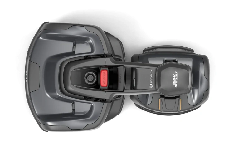 Robot koszący Husqvarna Automower® 435X AWD w kolorze ciemnoszarym. Widziany z góry, w pozycji leżącej. Przycisk START w czerwonym kolorze oraz czytelne logo auto mower są dobrze widoczne. Kształt ergonomiczny, z zaokrąglonymi krawędziami.