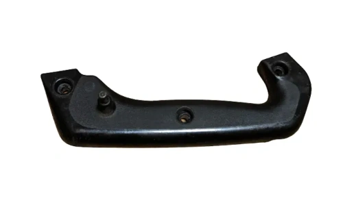 Uchwyt dmuchawy 132BT Husqvarna w kolorze czarnym, wykonany z tworzywa sztucznego. Produkt leży poziomo, widoczne otwory montażowe. Kształt ergonomiczny, gładka powierzchnia. Element przeznaczony do mocowania na urządzeniu.