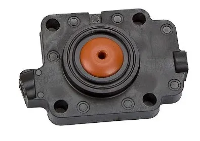 Korpus gaźnika dmuchawy 150BF Husqvarna, czarny, plastikowy z pomarańczowym elementem i oznaczeniami. Ujęcie frontalne, produkt leży na płaskiej powierzchni. Widoczne wyżłobienia i otwory montażowe.