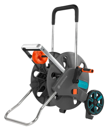 Wózek na wąż CleverRoll L Easy Gardena w kolorze szarym z elementami w pomarańczowym. Widok z boku, produkt stojący na stabilnej podstawie. Widoczny wąż na rolce oraz uchwyty do przenoszenia. Materiał plastikowy, metalowe rączki.