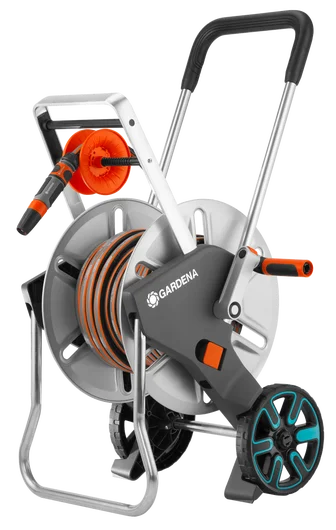 Zestaw wózka na wąż Gardena CleverRoll M Metal, szaro-czerwony, z metalową ramą, pomarańczową rolką, ergonomiczną rączką i elementami mocującymi, stojący na podłodze, widok z boku.