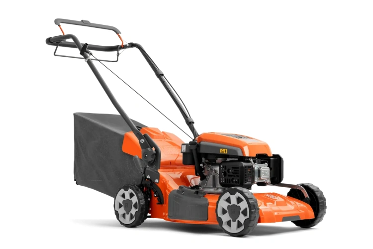 Spalinowa kosiarka Husqvarna LC 151S w kolorze pomarańczowym, z silnikiem widocznym z boku. Została zaprezentowana w pozycji stojącej. W komplecie z wysoko wydajnym koszem na trawę. Logo Husqvarna i czytelne oznaczenia na obudowie.