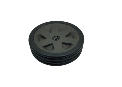 Zespół koła do kosiarki Husqvarna LC 551iV, czarny, z solidnego plastiku z wyraźnym wzorem. Ujęcie z góry, okrągły kształt, otwór na oś w centrum, na płaskiej powierzchni.
