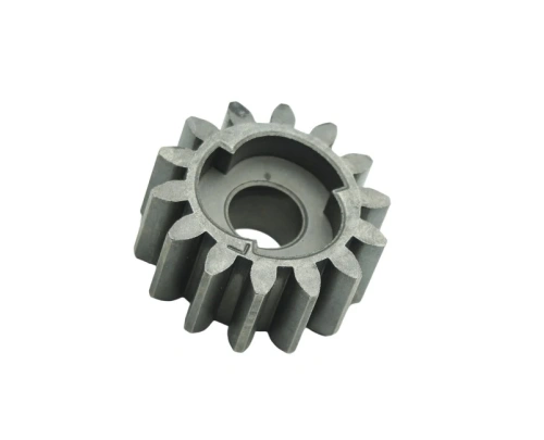 Zębatka do kosiarki LC 140S Husqvarna, wykonana z metalu, o cylindrycznym kształcie z wyraźnymi zębami. Widoczny centralny otwór na wałek. Element w kolorze szarym, z delikatnie teksturowaną powierzchnią. Ujęcie z góry, na jednolitym tle.