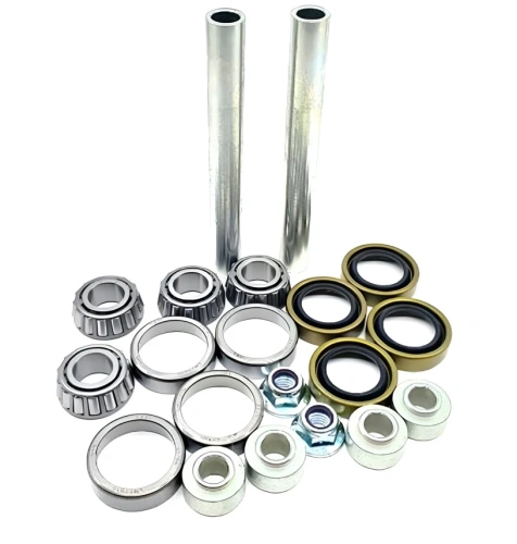 Zestaw serwisowy Husqvarna Z560X zawiera metalowe tuleje, łożyska, uszczelki i nakrętki. Na jasnym tle widoczne dwa metalowe pręty, srebrne łożyska oraz czarne i żółte uszczelki.