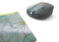 Moduł komunikacji GPS Automower Solar Hybrid Husqvarna, szary, o opływowym kształcie, leży na mapie drogi z widocznymi trasami i oznaczeniami. Ujęcie z góry ukazuje szczegóły produktu oraz fragment mapy ułatwiający lokalizację.