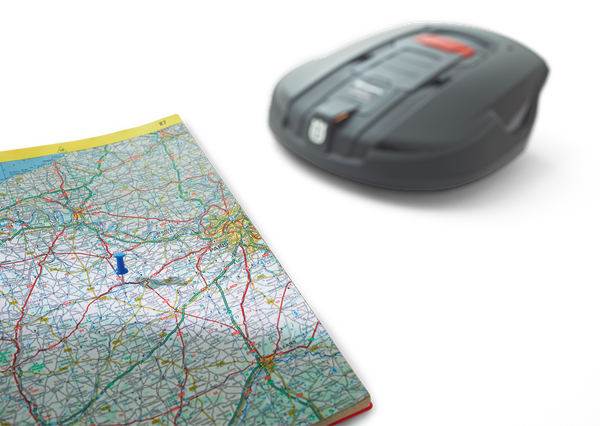 Moduł komunikacji GPS Automower Solar Hybrid Husqvarna, szary, o opływowym kształcie, leży na mapie drogi z widocznymi trasami i oznaczeniami. Ujęcie z góry ukazuje szczegóły produktu oraz fragment mapy ułatwiający lokalizację.