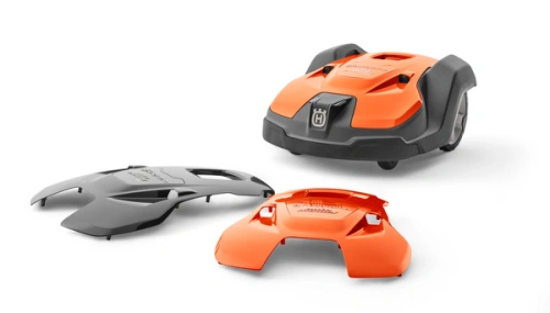 Obudowa 520 robota koszącego Automower 550 Husqvarna w kolorze pomarańczowym, stojąca z dwoma odczepionymi osłonami. Widoczna faktura materiału, logo Husqvarna na górze. Całość na białym tle, wyraźnie ukazująca detale.