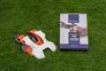 Obudowa 330x biała do robota koszącego AUTOMOWER 430X Husqvarna. Na zdjęciu widoczna jest biało-pomarańczowa obudowa leżąca na trawie oraz opakowanie z napisem TOP COVER. Obudowa ma gładką powierzchnię i ergonomiczny kształt.