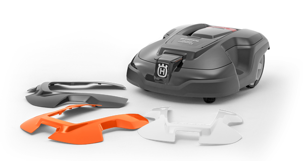 Obudowa robota koszącego Husqvarna AUTOMOWER 315X w kolorze szarym z wymiennymi osłonami w białym i pomarańczowym kolorze. Produkt widoczny z góry, złożony obok. Elementy są gładkie, z logo Husqvarna na głównym korpusie.