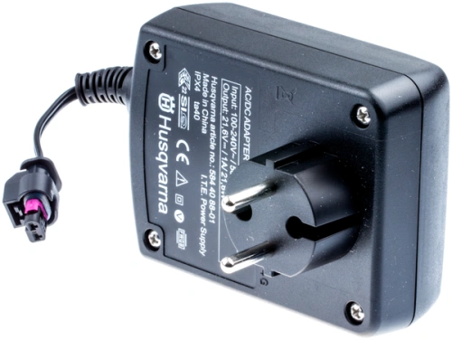 Zasilacz EU do robota koszącego Automower 305 Husqvarna, czarny, prostokątny. Widok z boku na wtyczkę, przewód, etykietę oraz logo i dane wejścia/wyjścia.